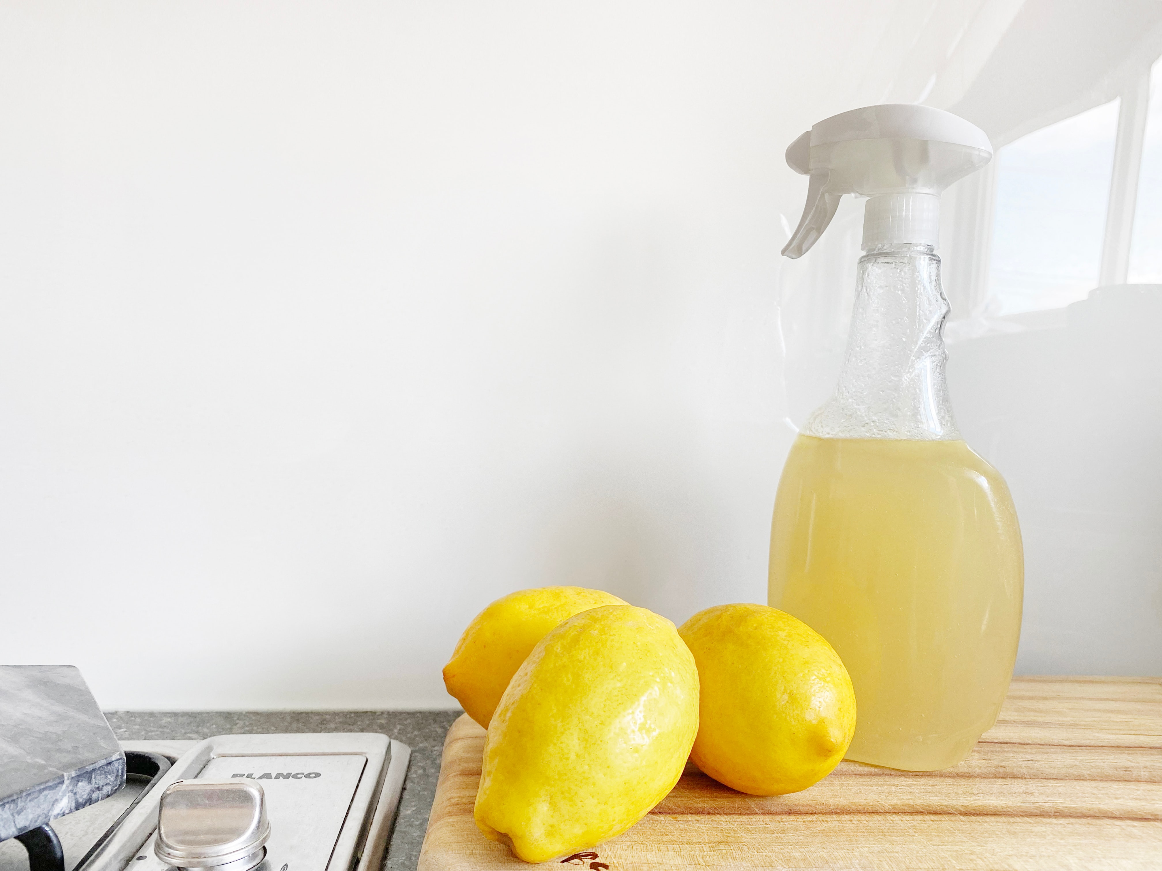 homemade cleaner and a group of lemons on a cutting board