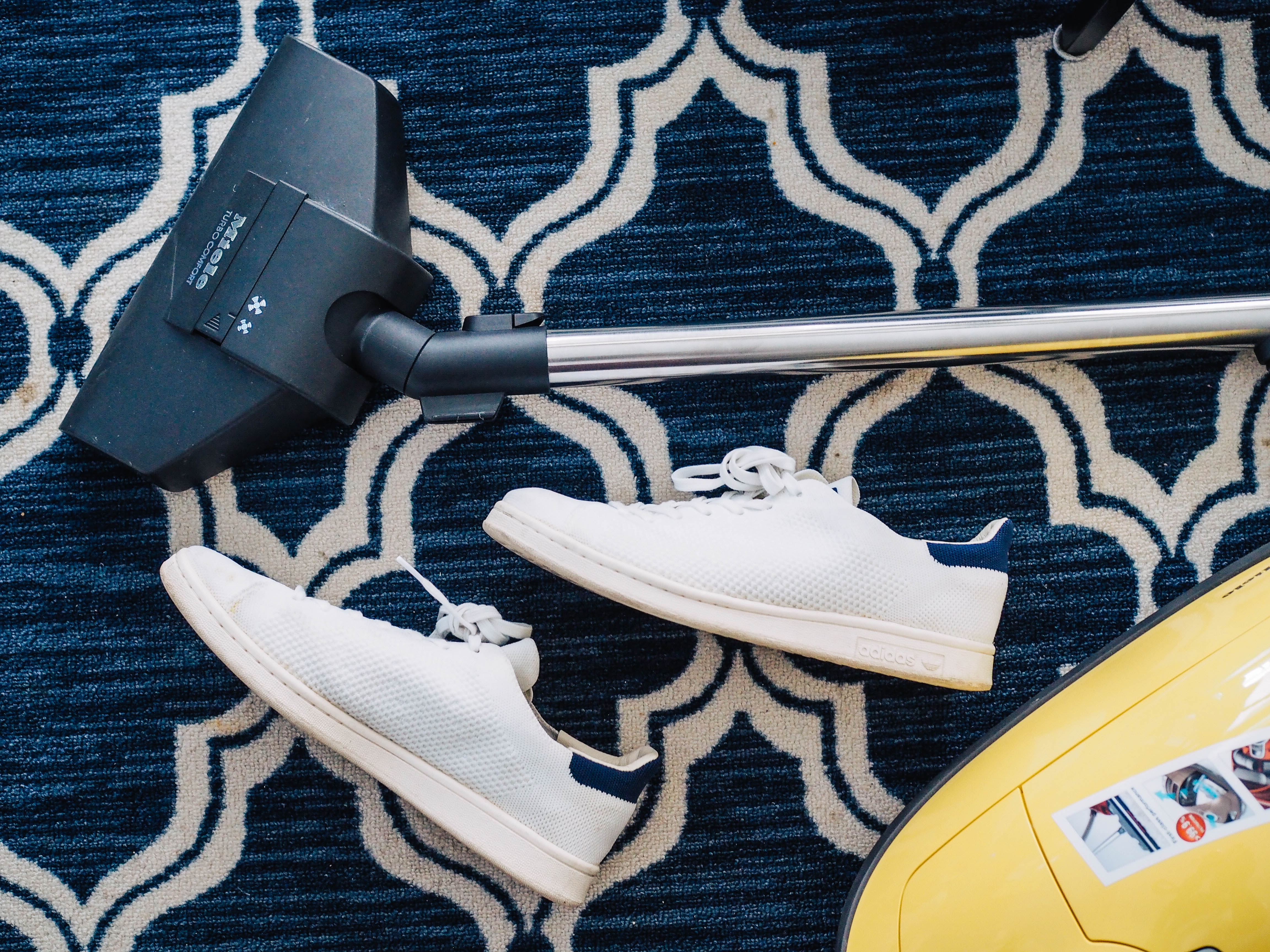 vacuum and sneakers on a dark blue rug