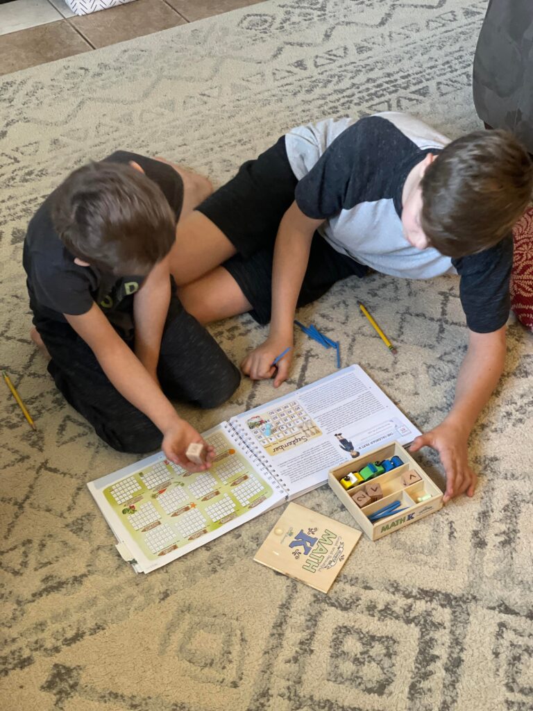 older boy helping a younger boy with his math lesson