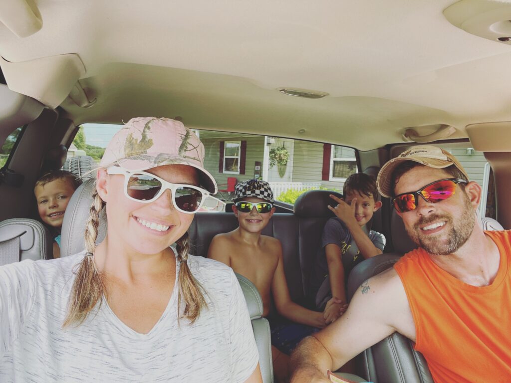 family of five in a truck heading to the river for canoeing