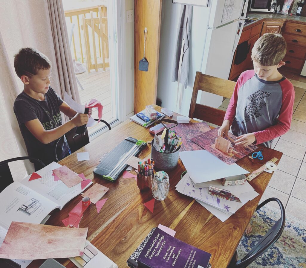 kids cutting paper and working at the kitchen table