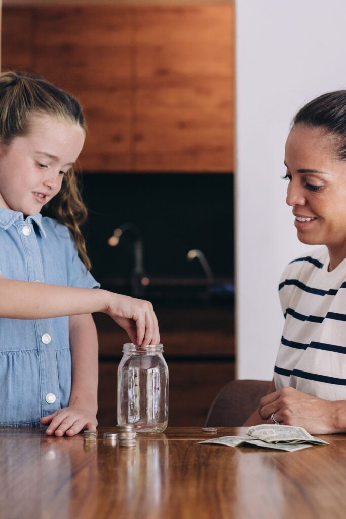 talking money with kids while putting coins in a jar