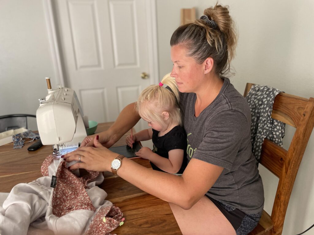 adorable helper sewing a sleeveless dress