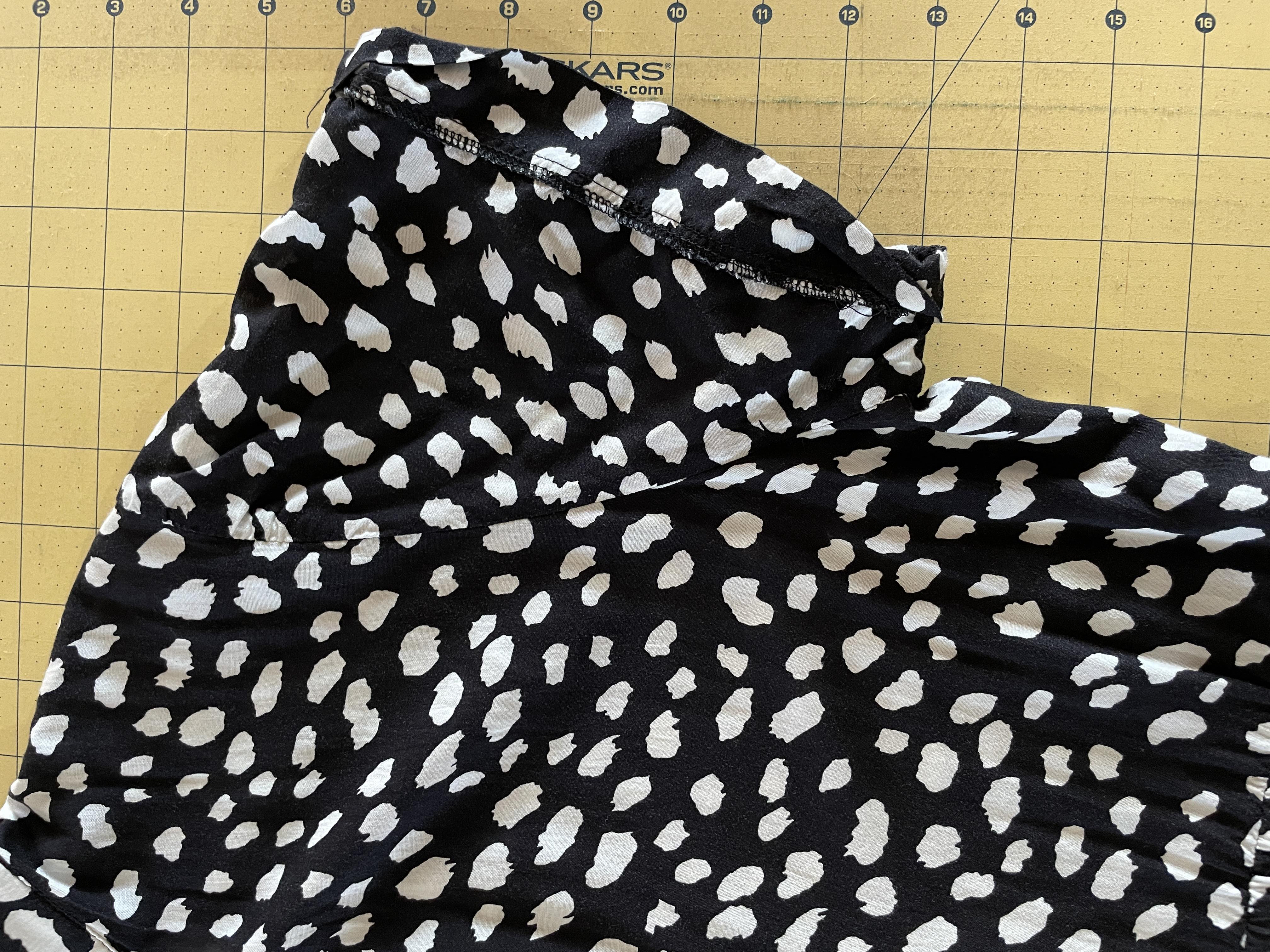 cutting off the sleeves of a black dress with white spots