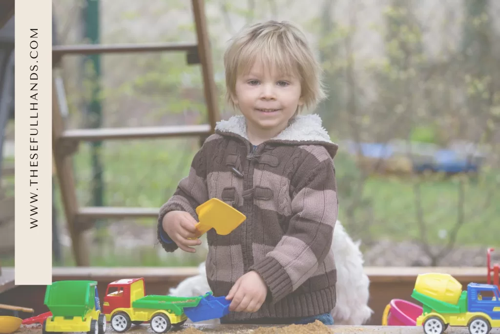 little boy playing with colorful trucks