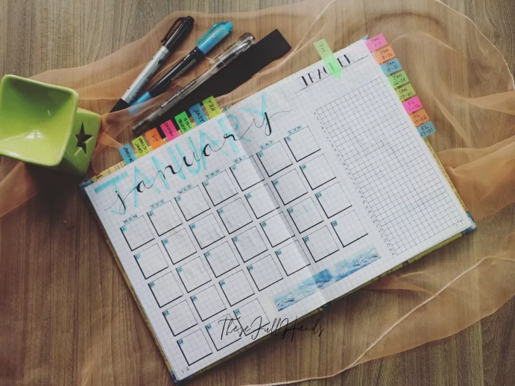 bullet journal planner laid open with pens and marker next to it