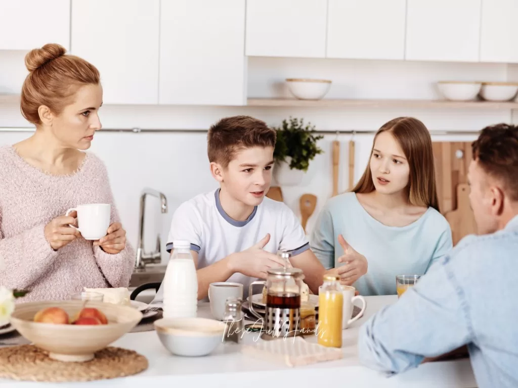 family of four sitting at breakfast together and talking