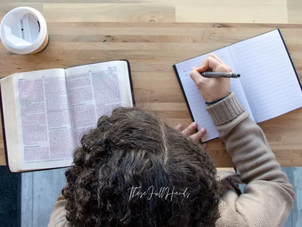 overhead of woman reading the Bible and journaling