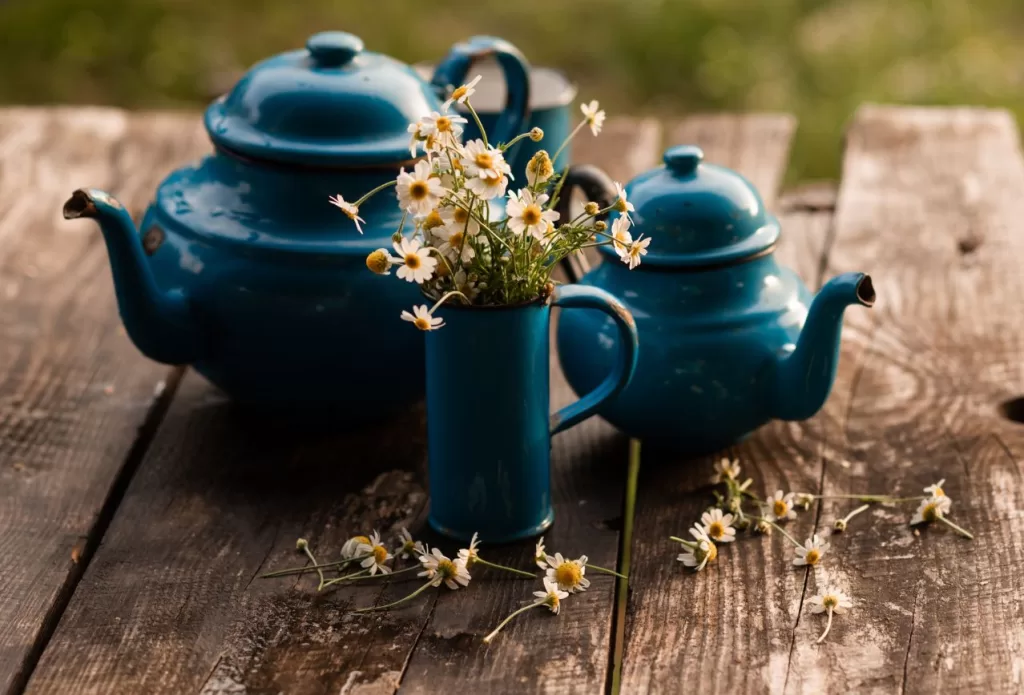 thrifted gifts of vintage blue tea pots and a vase with cut flowers