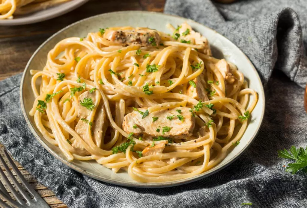 chicken pasta plate on a blue tea towel