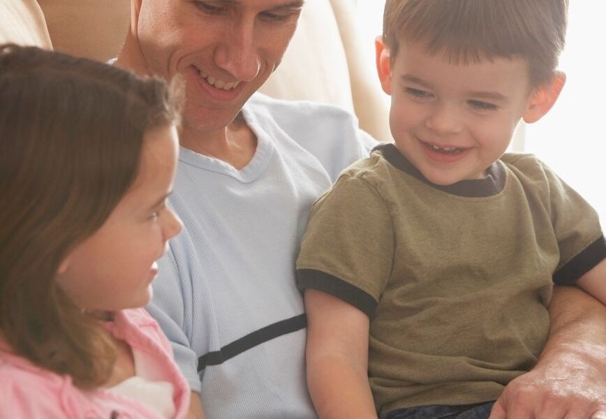 father and kids reading the Bible on couch