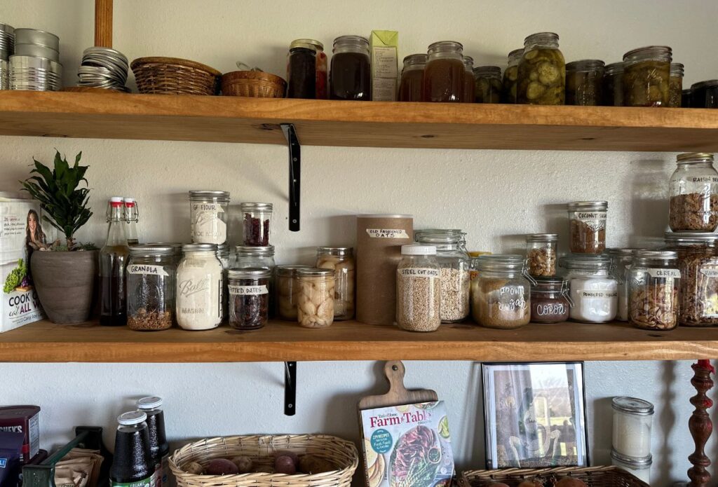 various glass jars of food on open shelves