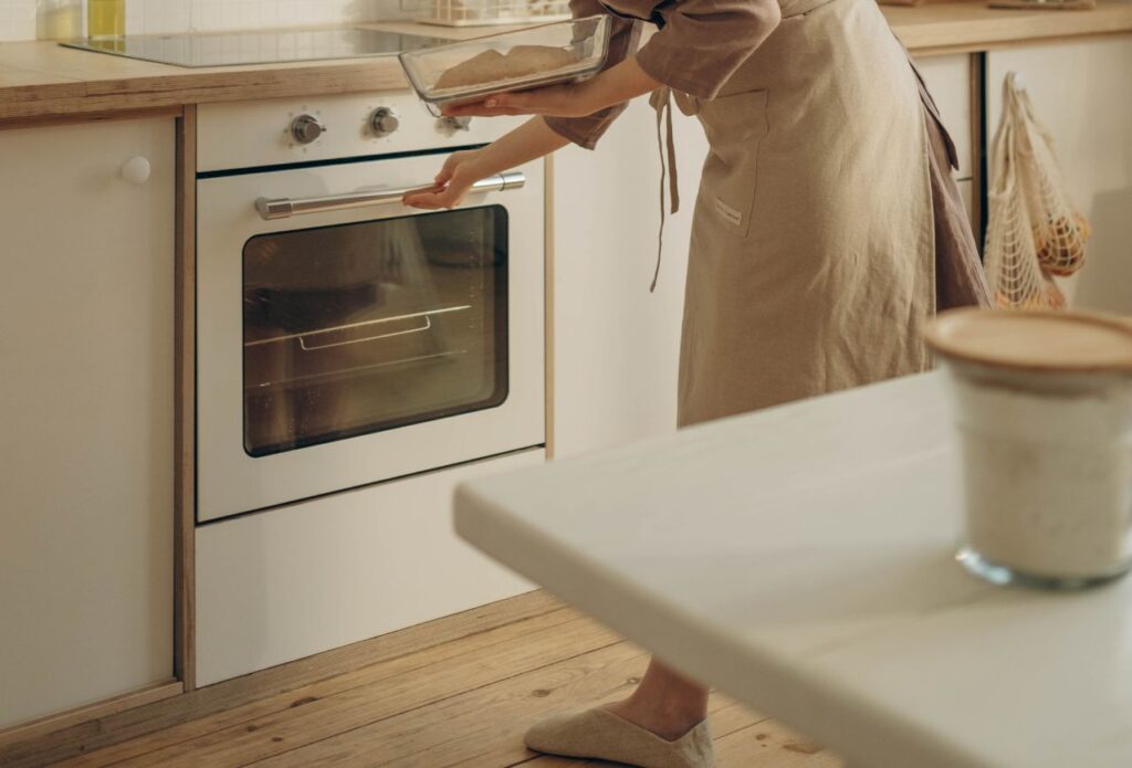 homemaker opening the oven to bake some sourdough being a homemaker is the most rewarding career