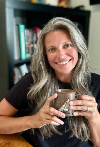 Woman smiling holding mug of coffee